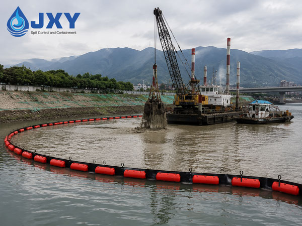 Heavy duty silt curtain deployed around dredging vessel during marine construction project