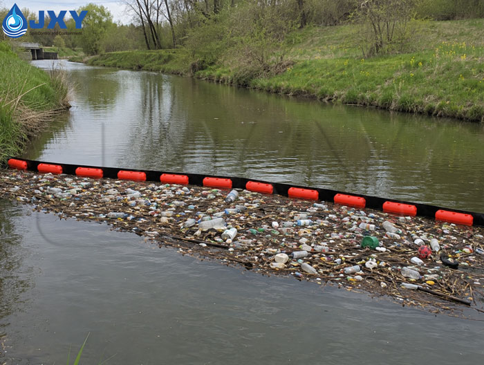 Floating debris boom installed across river for trash collection Floating debris boom installed across river for trash collection