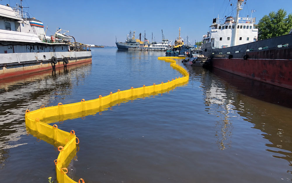 Fence type oil boom deployed for oil spill containment in port harbor